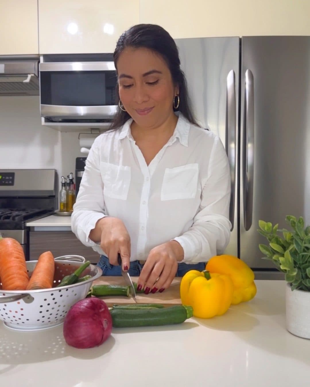 Sugey cortando verduras en su cocina
